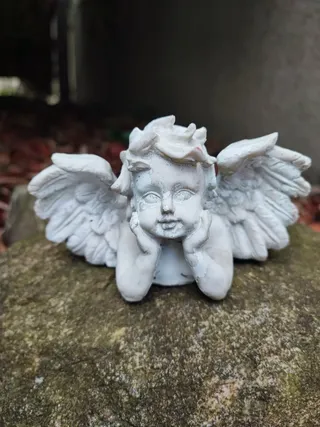 Engelsfigur auf einem Stein im Garten der Massagepraxis